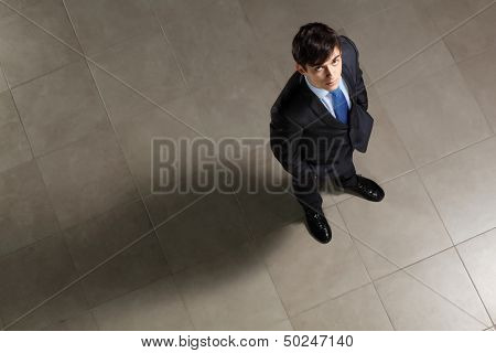 Image of young businessman looking above. Top view