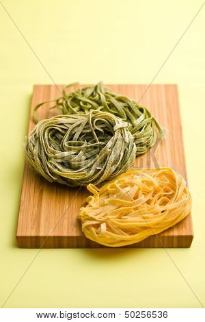 Italian pasta tagliatelle on color background