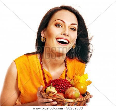 Woman holding autumn basket with fruit and vegetable.