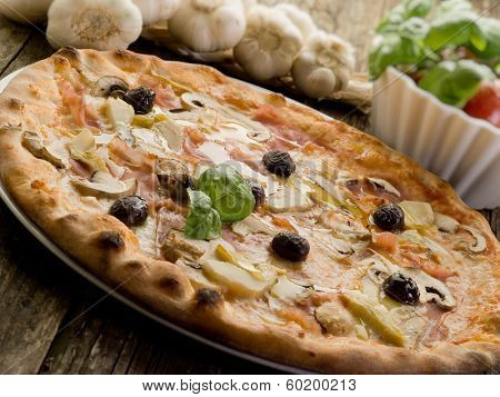 pizza capricciosa on dish over wood background