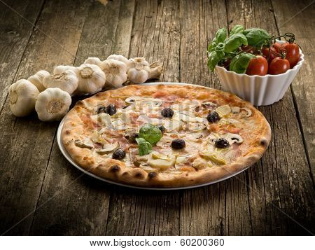 pizza capricciosa on dish over wood background