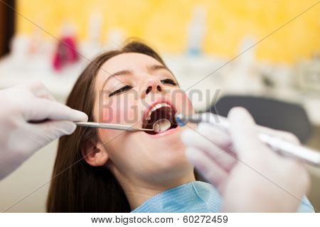 Dentist doing a dental treatment on a female patient