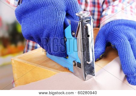 Fastening fabric and wooden box using construction stapler close up