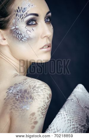 fashion portrait of pretty young woman with creative make up like a snake, fashion victim with pytho