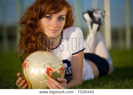 MÃ¤dchen mit Sommersprossen, liegend auf dem FuÃŸballplatz
