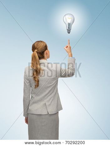 business, education, people and office concept - businesswoman or teacher in suit pointing finger up from back over blue background