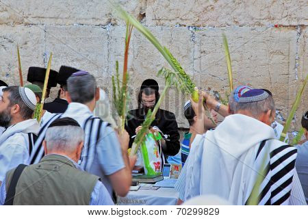 JERUSALEM, ISRAEL - SEPTEMBER 20, 2013: Morning Sukkot. Many religious Jews in traditional robes tallit gathered for prayer. The Western Wall of the Temple in Jerusalem