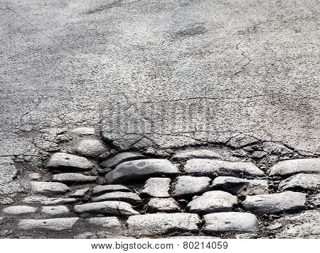 Cutting Of An Old Road With Cracked Asphalt And A Gully In The Center Of Cobblestones