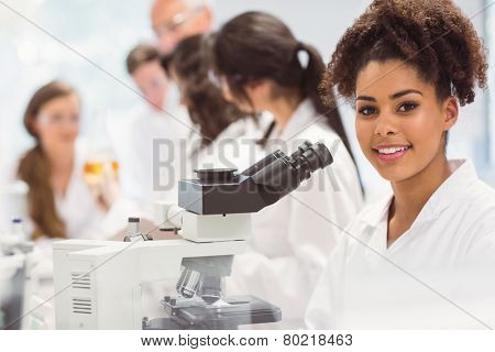 Science student looking through microscope in the lab at the university