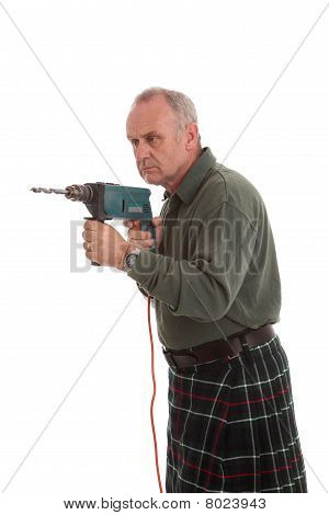 Reife Scotsman mit eine Bohrmaschine