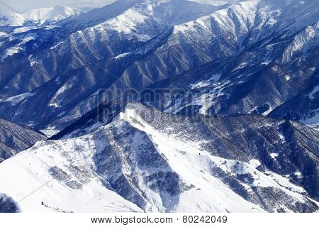 Top View On Snowy Mountains With Forest