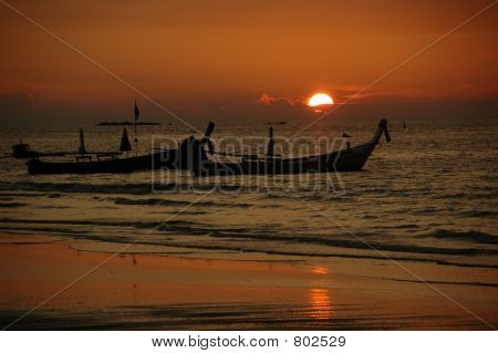 พระอาทิตย์ตกและ tailboats