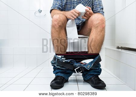 Man In Toilet Holding Tissue Paper Roll