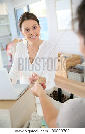 Customer in clothing store giving credit card to seller