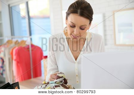 Beautiful shopgirl working in clothing store