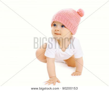 Portrait Of Sweet Baby Crawls In The Pink Knitted Hat And Looking Up