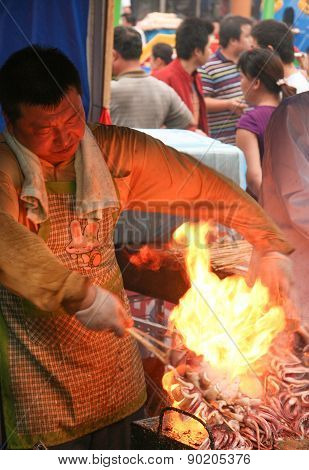 Man Frying Seafood On A Food Market In The Center Of Wuxi, Jiangsu Province, China