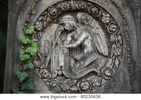 Mourning angel depicted in the abandoned tombstone at the Malostransky Cemetery in Prague, Czech Republic.