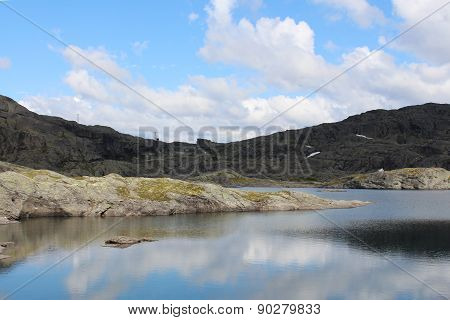 Mountains lake and blue sky with some clouds.