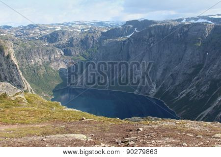 A lake is surrounded the mountains.