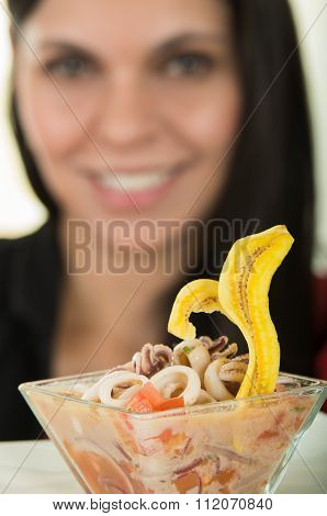 Beautiful young brunette girl enjoying a seafood cebiche
