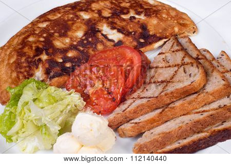 English breakfast with scrambled eggs, tomatoes, potatoes, toast and fresh salad