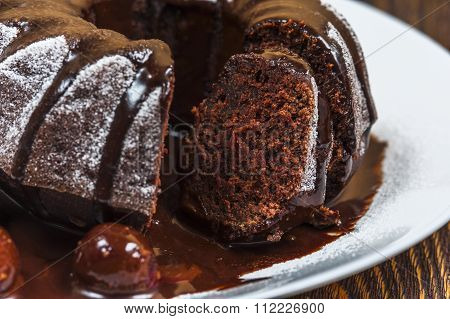 Chocolate cake with cherry on white plate