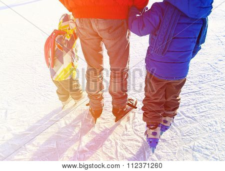father with two kids skating in winter