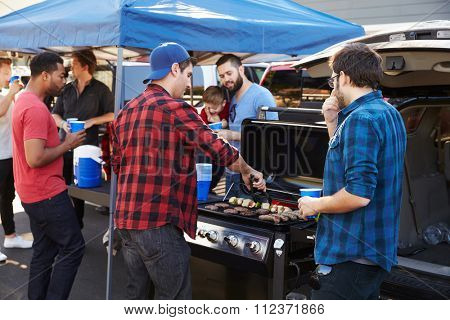 Group Of Sports Fans Tailgating In Stadium Car Park
