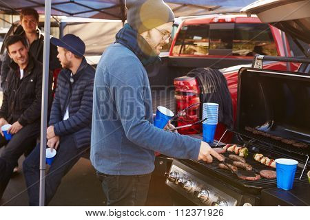 Group Of Sports Fans Tailgating In Stadium Car Park