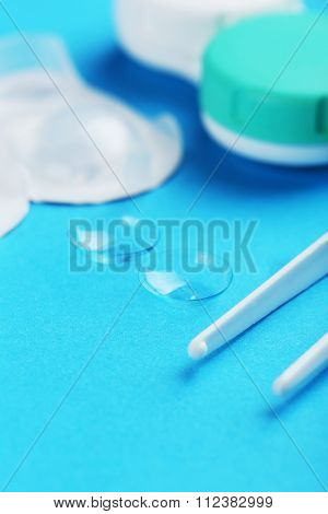 Contact Lenses In Container With Solution On Blue Background