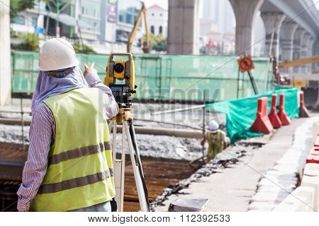 Engineer Instructing While Operating Dumpy Automatic Level Instrument At Site