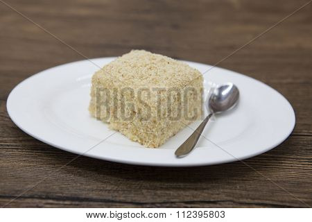Dukan Diet. Fresh delicious diet cake at Dukan Diet on a porcelain plate with a spoon on a wooden background