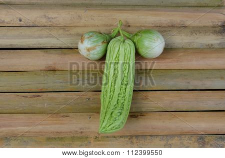 bitter cucumber and eggplant on bamboo table