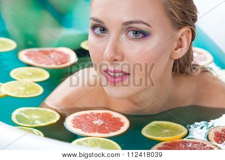 Beautiful woman with shiny skin in blue water