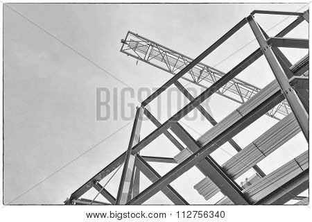 A Construction Site With Steel Framing And A Yellow Construction Crane