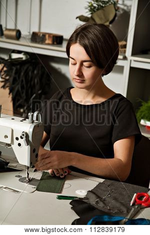The Girl Is Sewing On The Sewing Machine