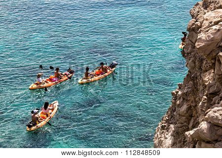 Tourists Kayaking At Tsigrado Beach In Milos Island, Cyclades, Greece
