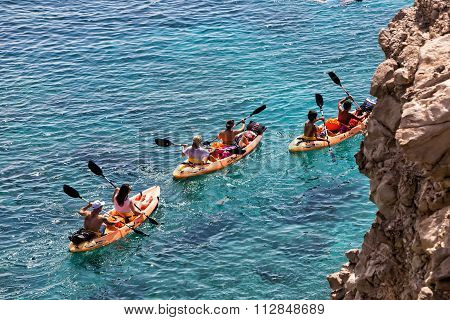 Tourists Kayaking At Tsigrado Beach In Milos Island, Cyclades, Greece