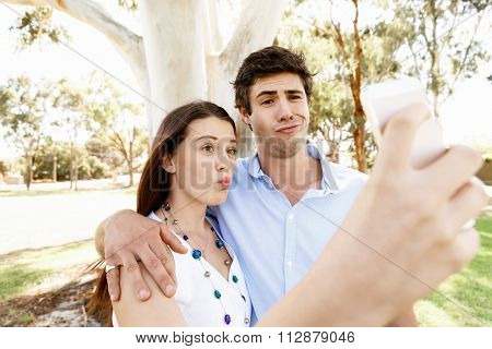 Young couple in the park making their selfi with mobile phone