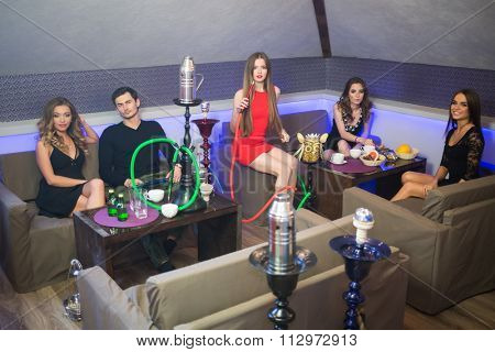 Four beautiful girls and one man have a rest in smoky room