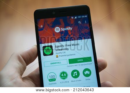 Los Angeles, november 2, 2017: Man hand holding smartphone with Spotify application in google play store
