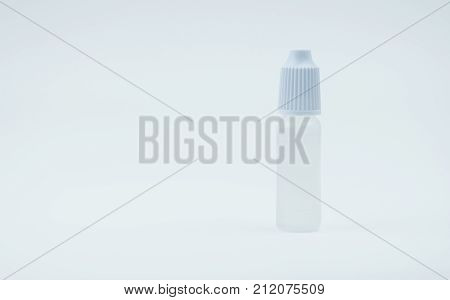 Eye drops bottle with white cap on white background with blank label and copy space just add your own text. Dry eye disease from smartphone use digital screen. digital eye strain.