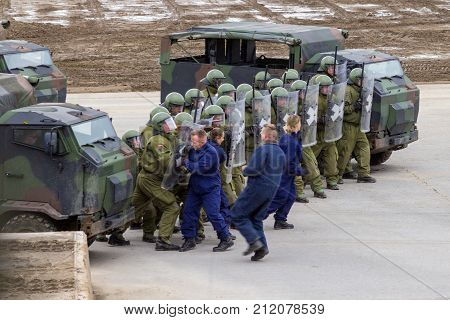MUNSTER / GERMANY - OCTOBER 9 2017: german military police soldiers defends an area against role playing demonstrators