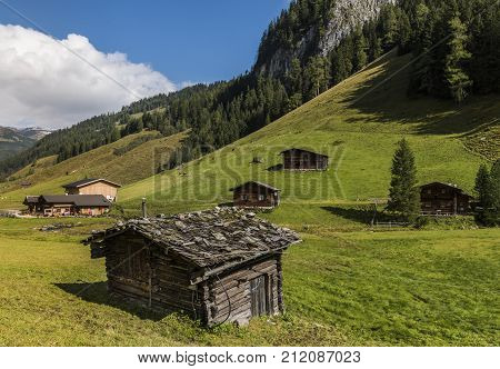 Cabins in Wildgerlostal valley with old cabin and small creek in summer in national park Hohe Tauern Salzburg Austria.
