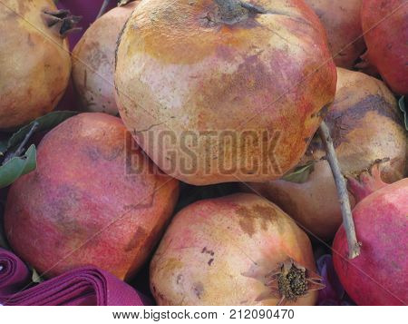 seasonal fruits of red and yellow pomegranate on basket