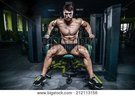 Handsome Model Young Man Training Legs In Gym