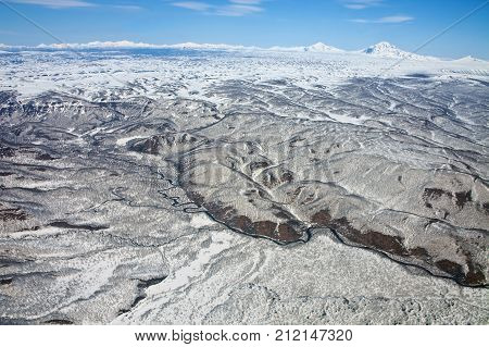 Views of the foothills of the Karymsky volcano from a helicopter after a spring snowfall on the Kamchatka Peninsula. Russia