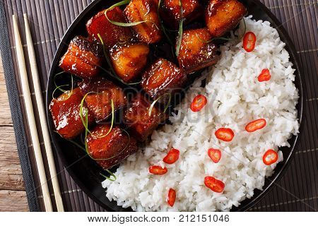 Vietnamese Caramel Pork With Garnish Of Rice Close-up On A Plate. Horizontal Top View