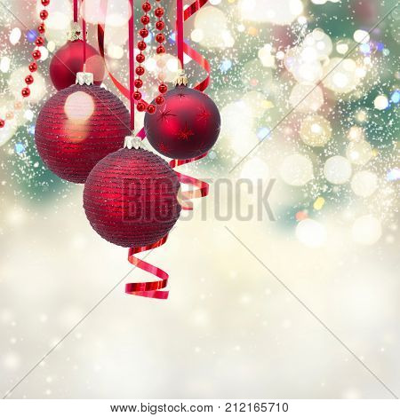 Red christmas balls and evergreen fir tree on gray winter background with sparkling bokeh